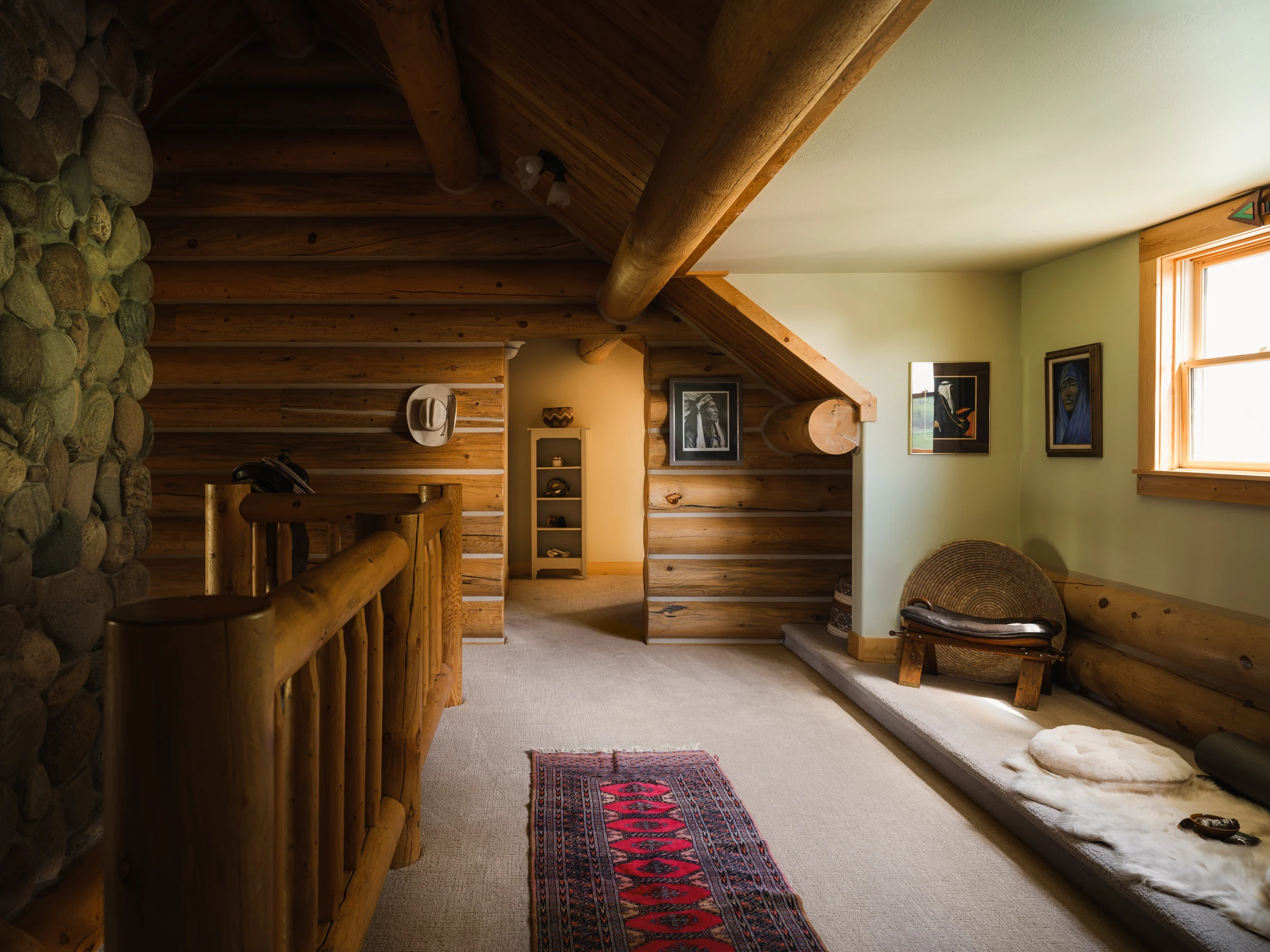 Upstairs landing with log stairwell railing and a guest nook — architectural photography Livingston Montana, Sam Schlauch Designs
